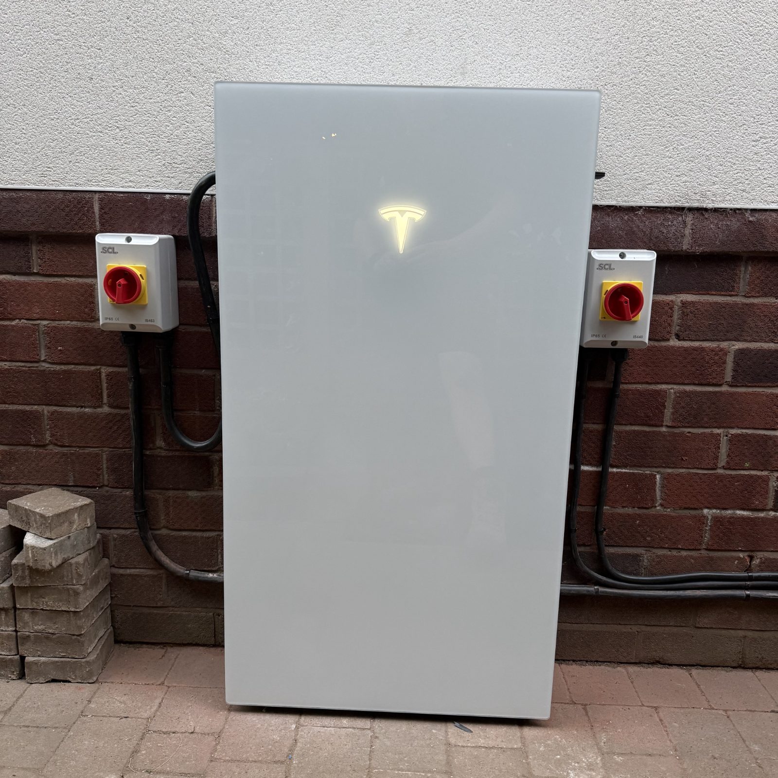 Powerwall lifting dolly in use on an install, showing the drill-driven lead-screw lift